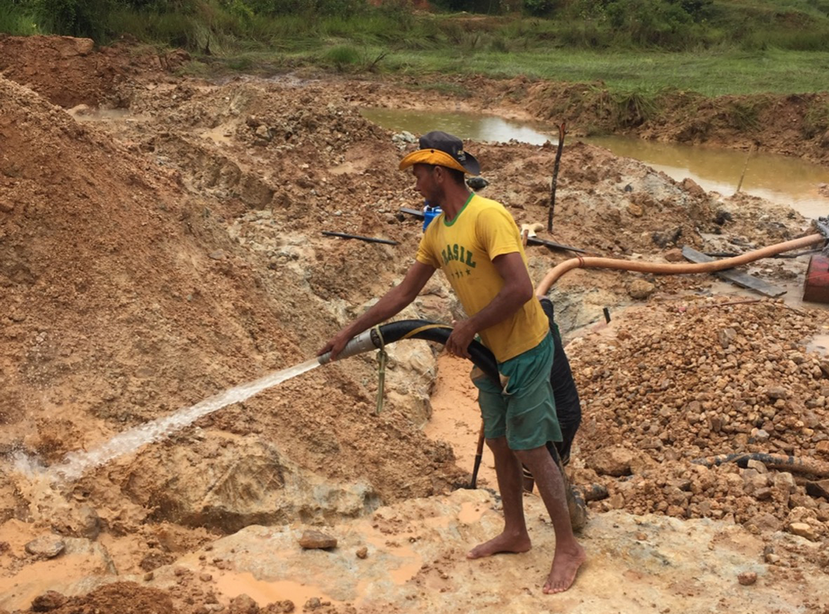 Gold Digger Shows Tourists Alluvial Gold Sand Mined in the Mine on