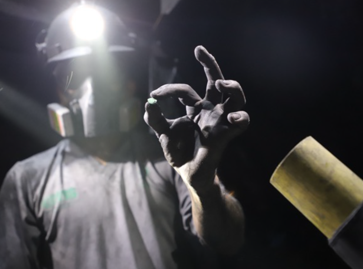Miner holding emerald rough in the Muzo mine. (Photo courtesy of Muzo Emerald Colombia.)
